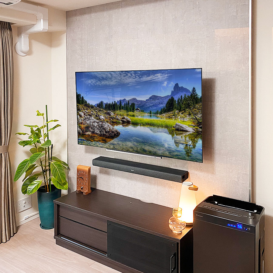 外装に石目調タイルの「エアストーン(スモーク)」を採用、テレビ下にはサウンドバーも壁掛け。