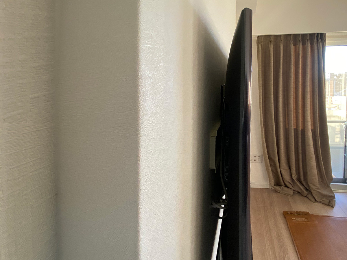 側面からの様子。壁掛け金具は薄さを重視した角度固定式タイプを採用。テレビ裏の空きスペースを利用し録画用のハードディスクを設置することもできます。