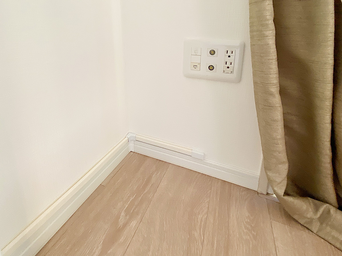 今回の壁面にはコンセントがなかったため、対角90度の壁コンセントから100ボルト電源とアンテナ線をL字型に延長しました。そのままではケーブルが目立つので、お部屋の壁色に合わせたケーブルカバーで目立たなくしております。