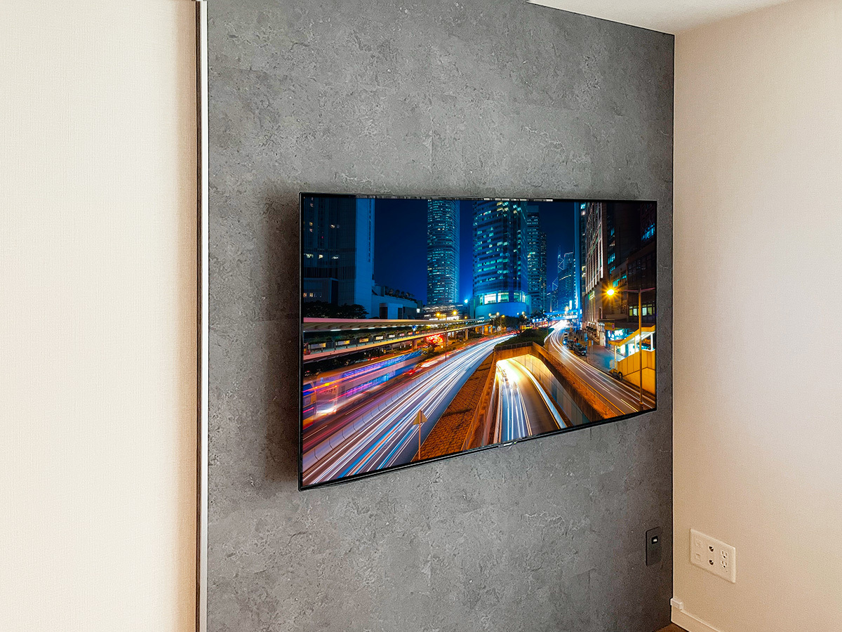テレビはシャープのアクオス4T-C55DQ1。カトー電器でご購入いただきました。壁掛け時の本体サイズは横幅1228mm、高さ721mm、厚みは最大で59mm、重量は22kgです。