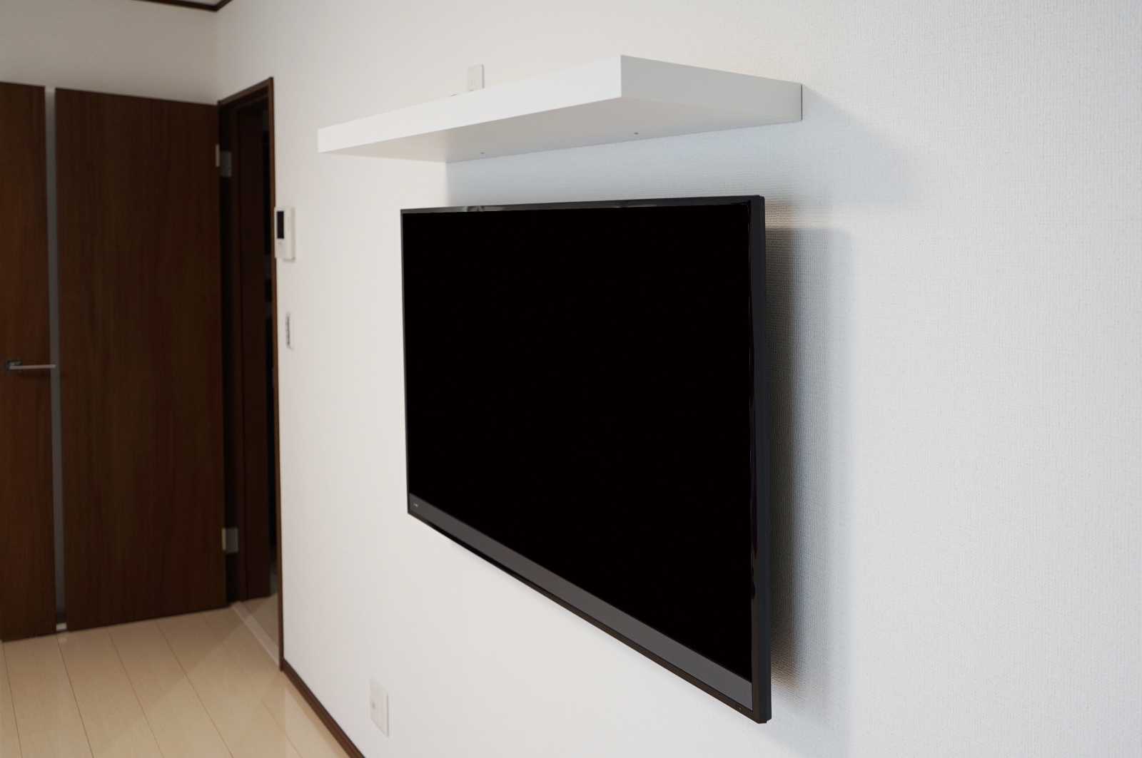 広い壁のフラット感とマッチする壁掛けテレビ