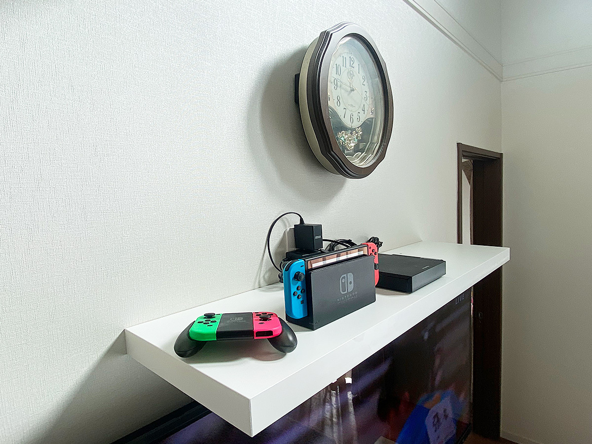 ウォールシェルフの様子。さっそく録画用のハードディスク2台とゲーム機の置き場として利用されています。USBケーブルやHDMIケーブルは専用コンセントを経由して壁掛けテレビへ。