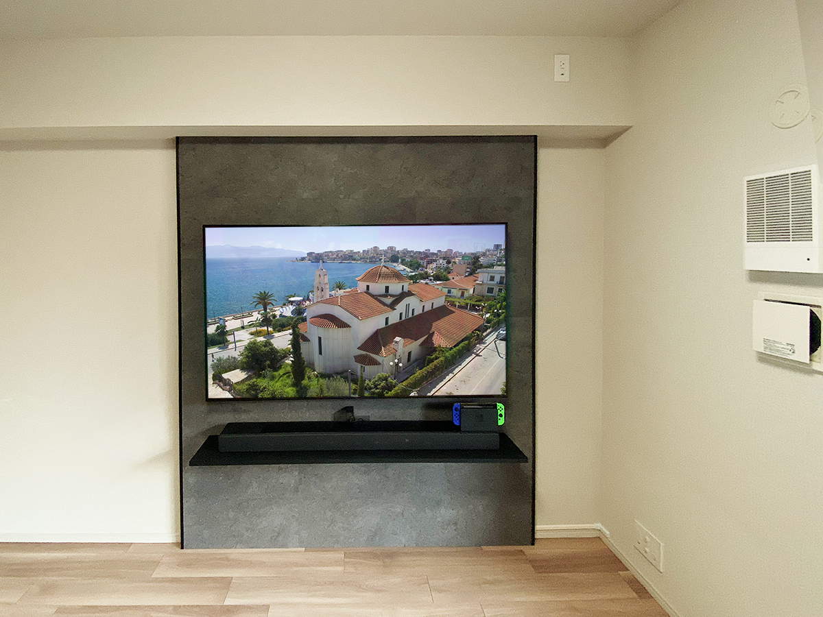 東京都練馬区のマンションでフェイクウォールPIXYを設置。外装はエアストーン仕上げ。テレビはソニーブラビア65インチ。テレビ下にはサウンドバーの置き場として棚も設置しました。