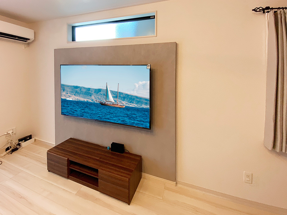 フェイクウォールの足元は巾木（はばき）を追加するとぐっと引き締まります。テレビは東芝のレグザ「65Z670N」65型の液晶テレビ。お客様がご用意されました。