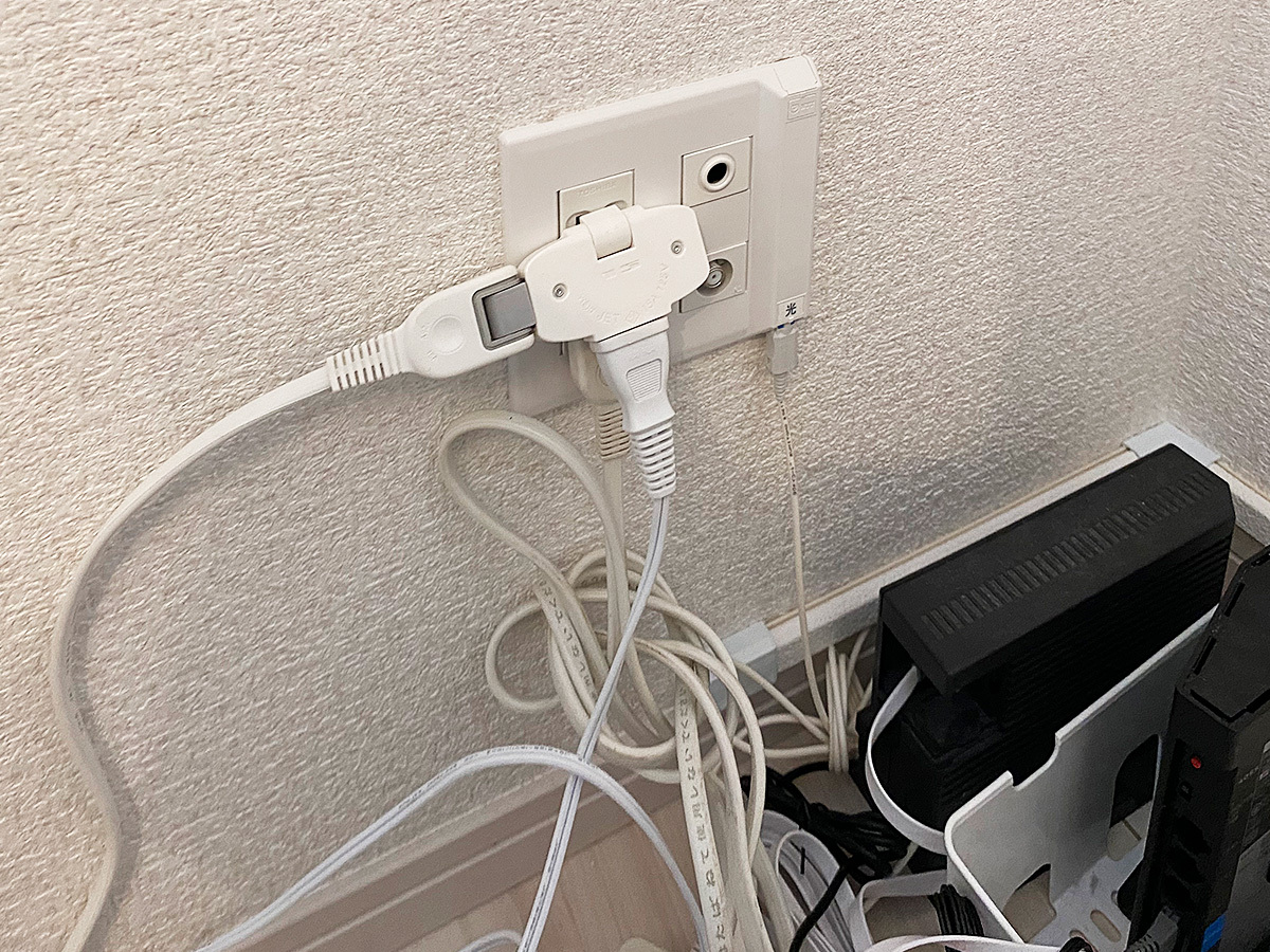 90度対角壁のコンセント。ここにアンテナ端子があるため、壁内部で一旦分岐させ床上ぎりぎりの所から線を表に出しL字状に延長しています。