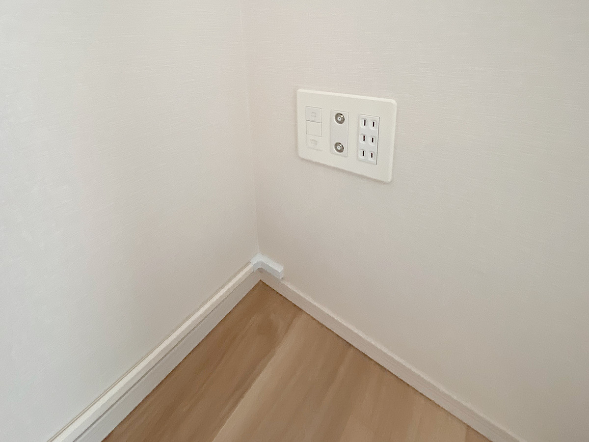 ご希望の壁面にコンセントが無いため、90度対角面のコンセントから電源やアンテナ線を延長しています。ここでも壁内で分岐させ、モールと呼ばれる配線カバーで覆い隠しました。