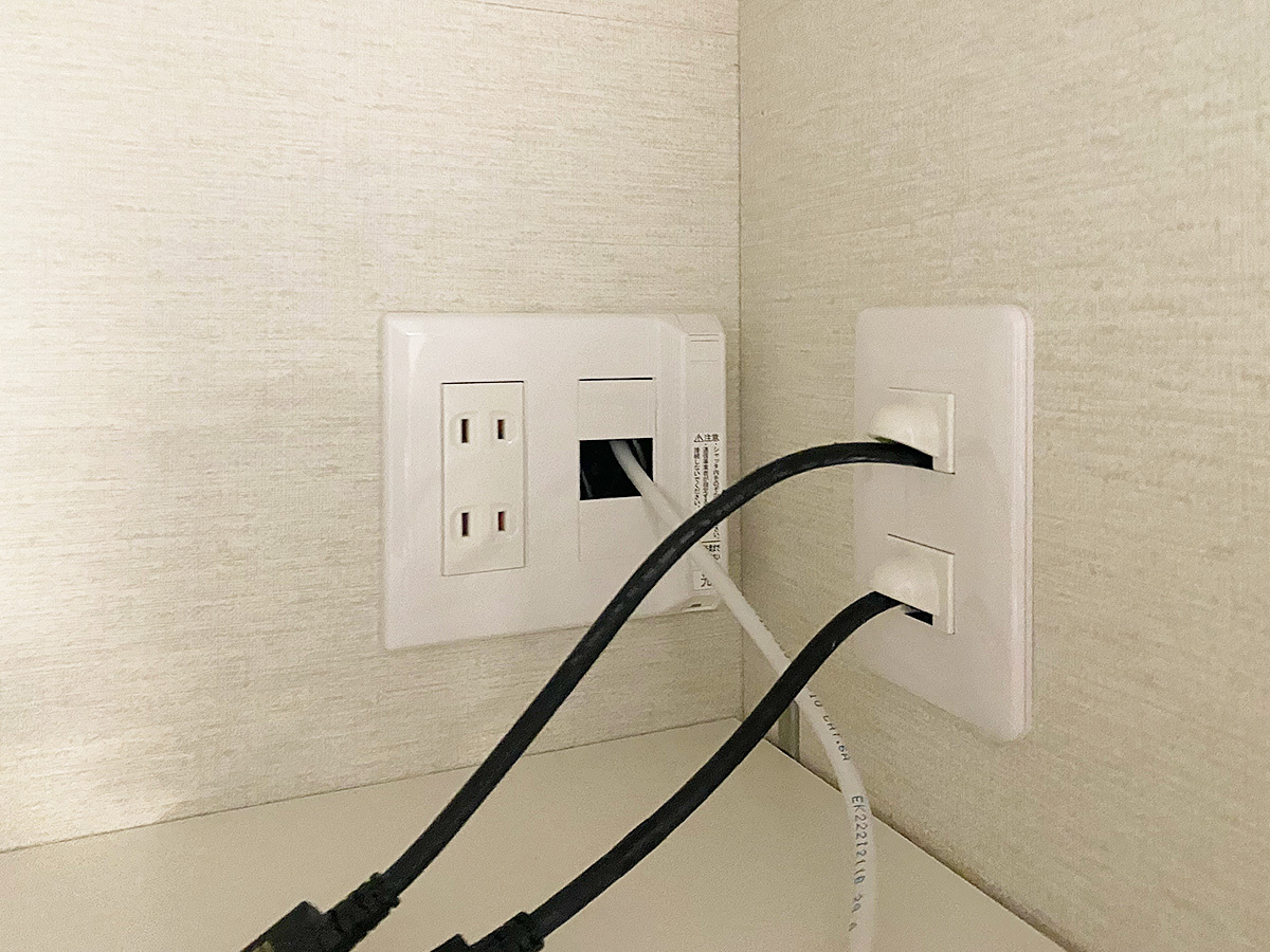 右側のコンセントがカトー電器製。壁掛けテレビから2本のHDMIケーブルが壁内を通してここに出てきます。