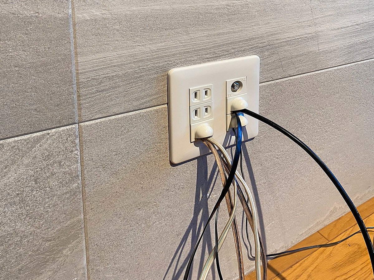エコカラット壁に新しく作られたテレビボード用のコンセント。壁内を通してテレビとつながる各種ケーブル類が多数確認できます。PIXYならお好きな場所にコンセントを増やせます。

