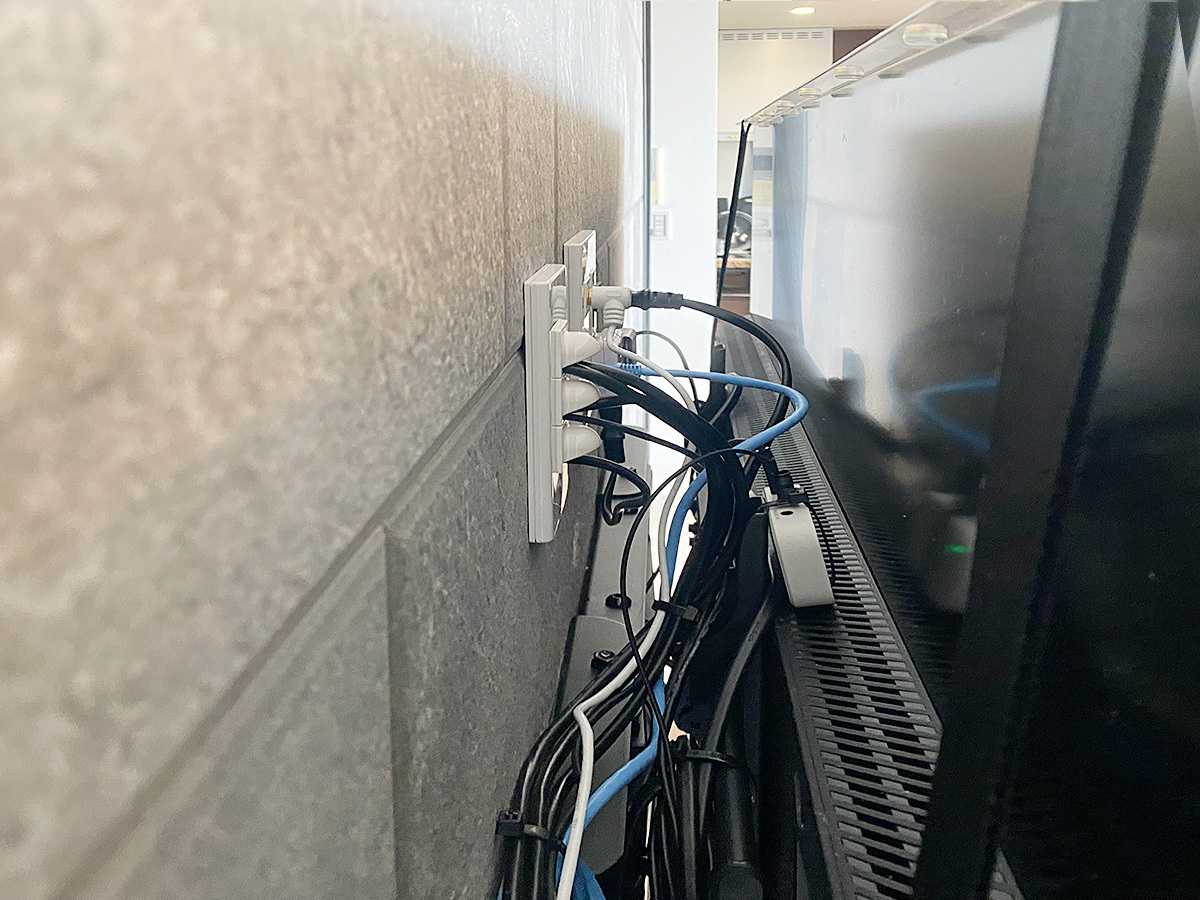 テレビの背面。金具は上下左右に角度が調節できる可動式タイプを採用し、アンテナ線やHDMIケーブルなどをまとめて壁内に通しています。
