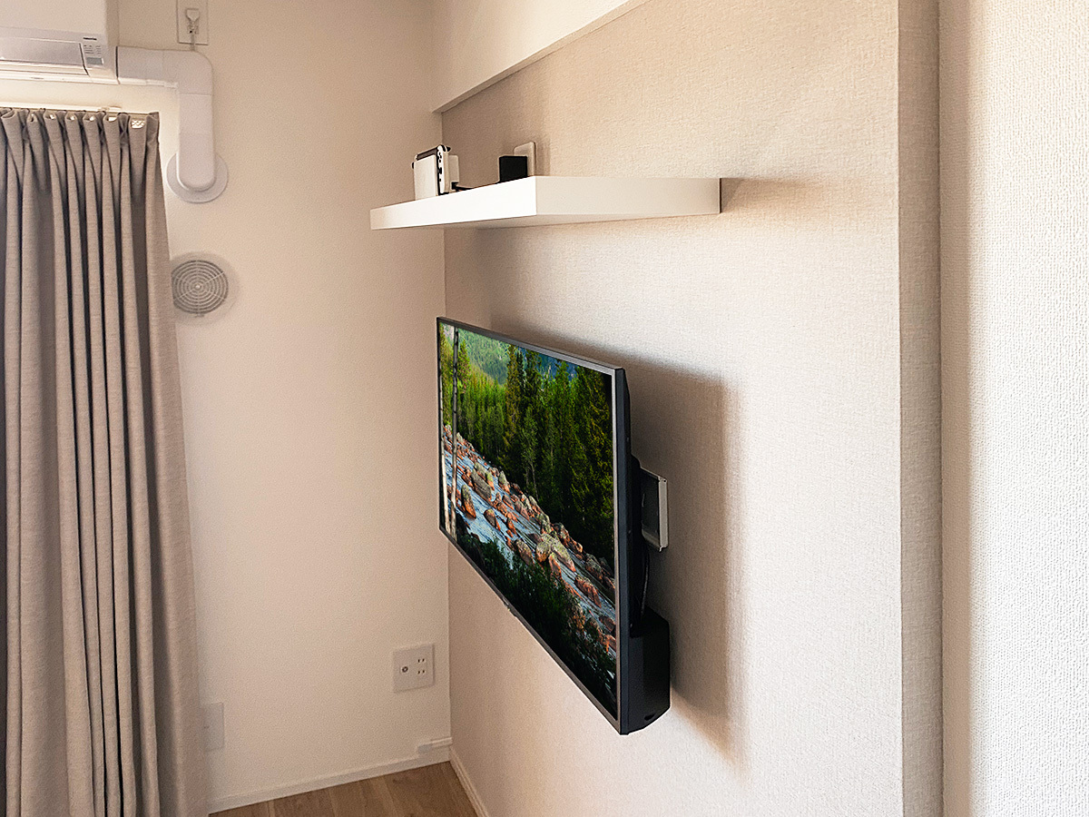 壁掛け金具は角度固定式タイプを採用。PIXYとテレビとのスペースを活かして録画用のハードディスクを設置しています。