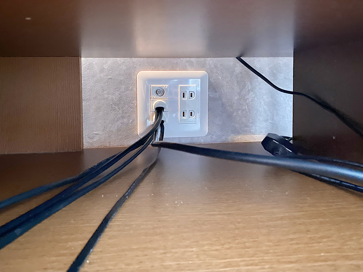 テレビボードで隠れる場所にもコンセントパネルを新設しました。壁掛けテレビからPIXY内を経由して4本のHDMIケーブル類が出てきているのがお分かりいただけると思います。