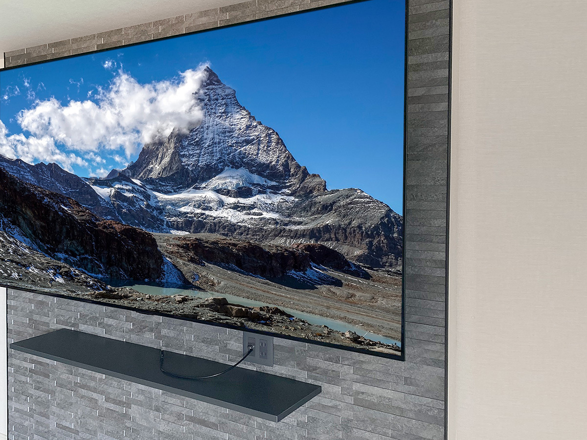 テレビで隠れる位置に専用コンセントを作り、そこに電源やアンテナ線などを接続しています。テレビを壁掛けにすることで80インチ超でも奥行きはほとんどとりません。