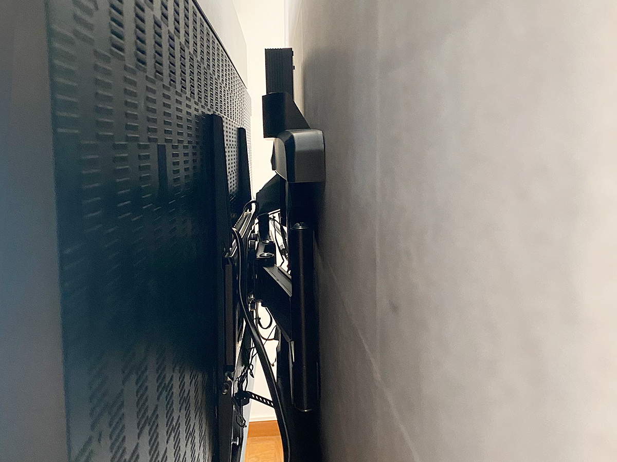 壁掛け金具は可動式タイプ。手前に引き出すことで左右に首振り可能です。テレビの背面スペースを活用し、録画用の小型ハードディスクを取り付けました。