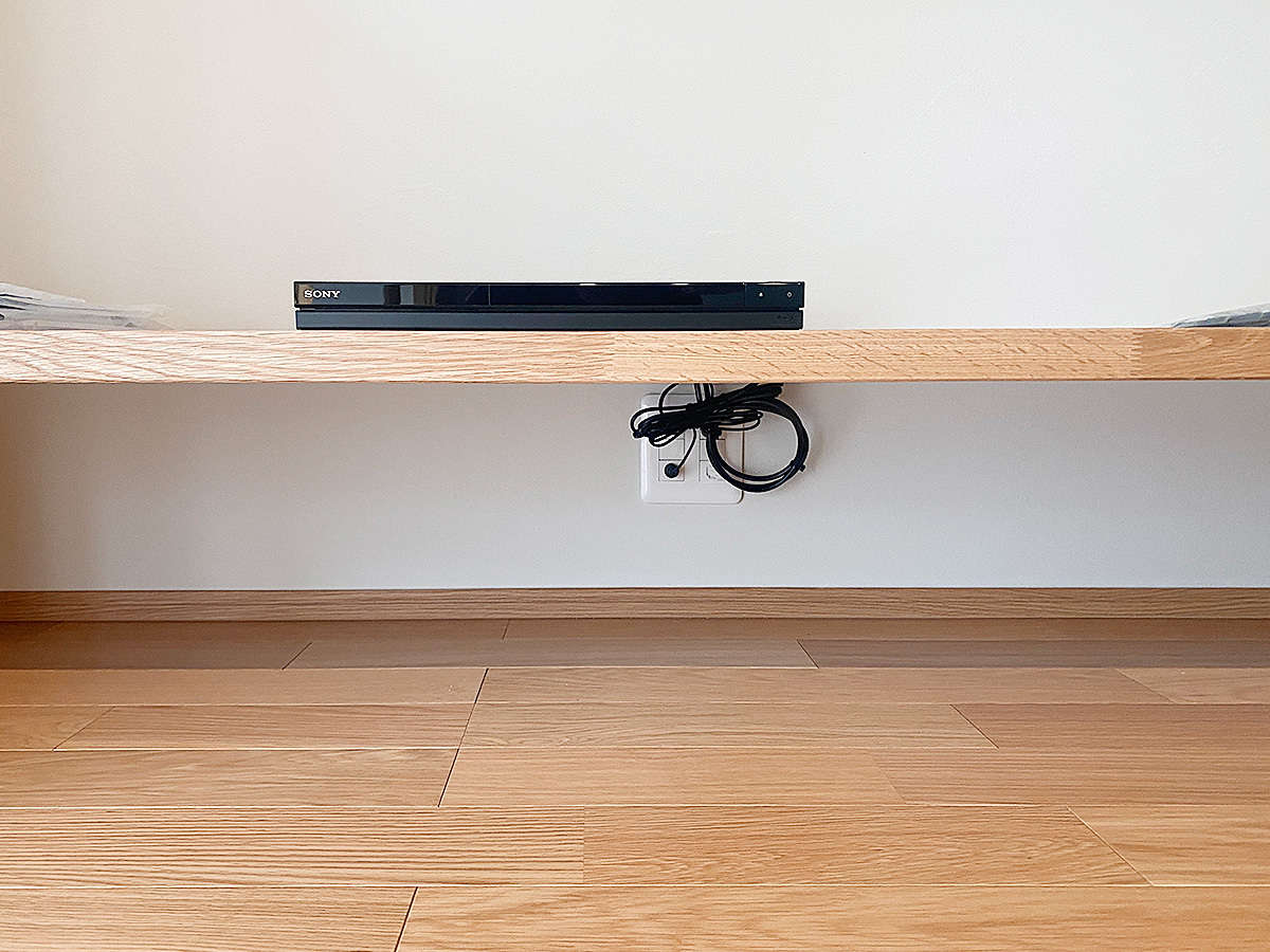 レコーダー機器は棚下に作られた専用コンセントに接続。ここから壁掛けテレビまでは壁内配線経由です。