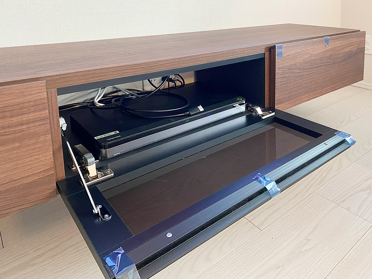 PIXYに壁掛けしたパモウナのフロートテレビボード。中にはレコーダ機器などを収納。奥に新設したコンセントが見えます。