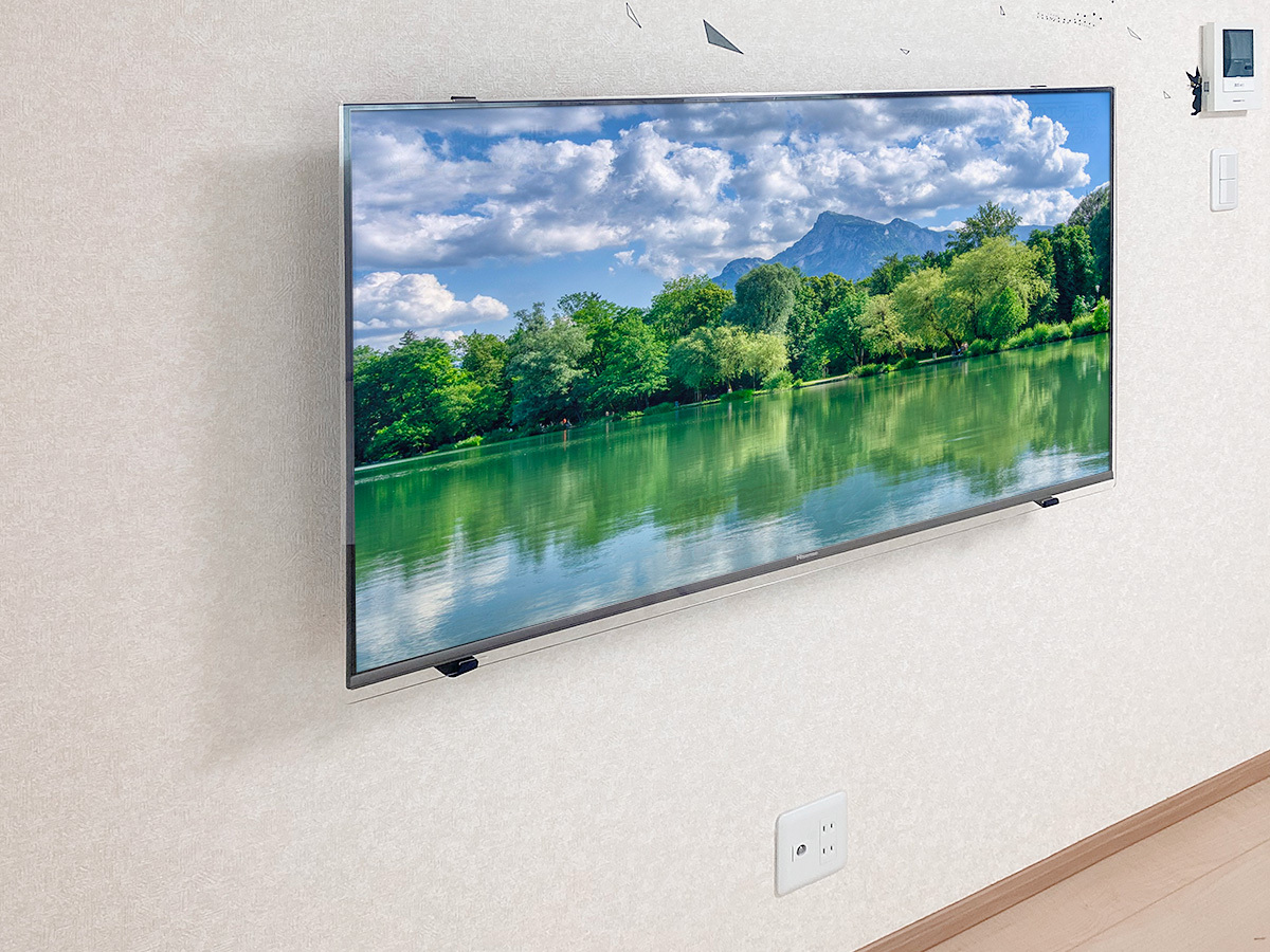 床上に見えている既存コンセントを一旦分解し、100ボルト電源とアンテナ線を分岐。テレビで隠れる位置に新しくコンセントを作りました。