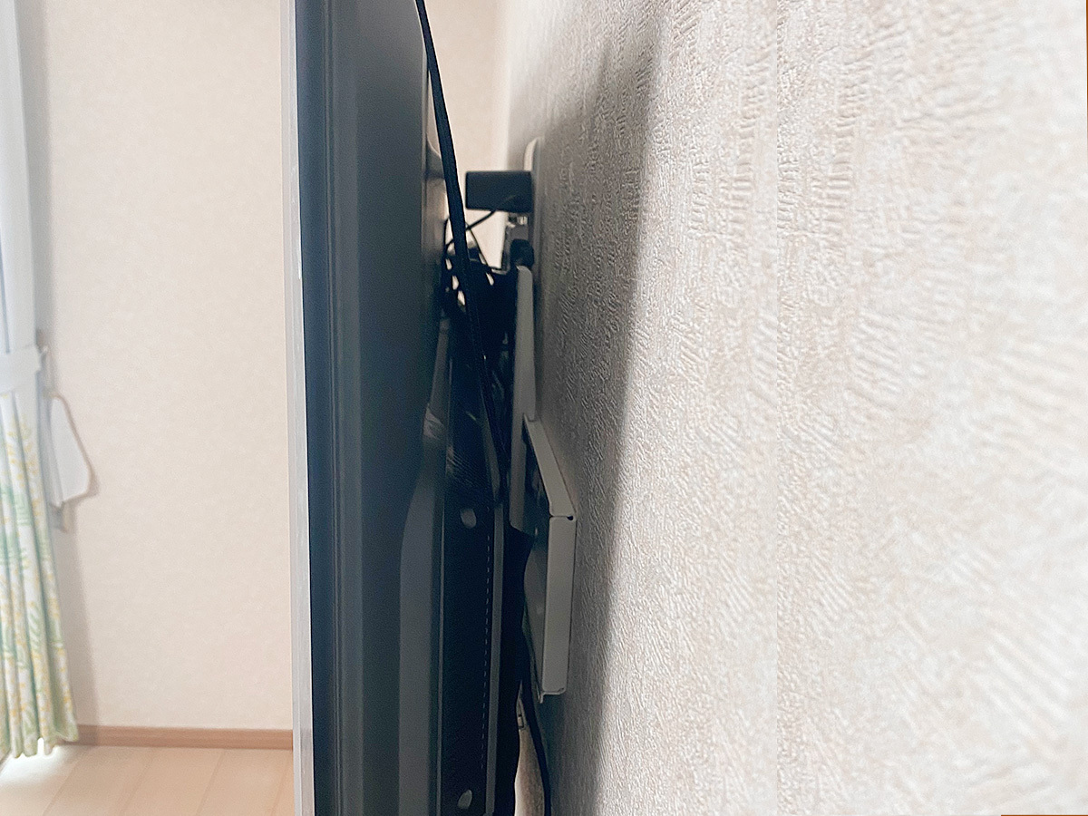側面から覗き込んだところ。壁面の上に直接壁掛け金具(ホワイト)を設置しているのが分かります。