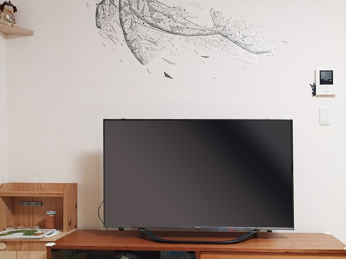 工事前にお客様から送っていただいた現状の壁写真。テレビボードの上にテレビが置かれたオーソドックスな使われ方でした。