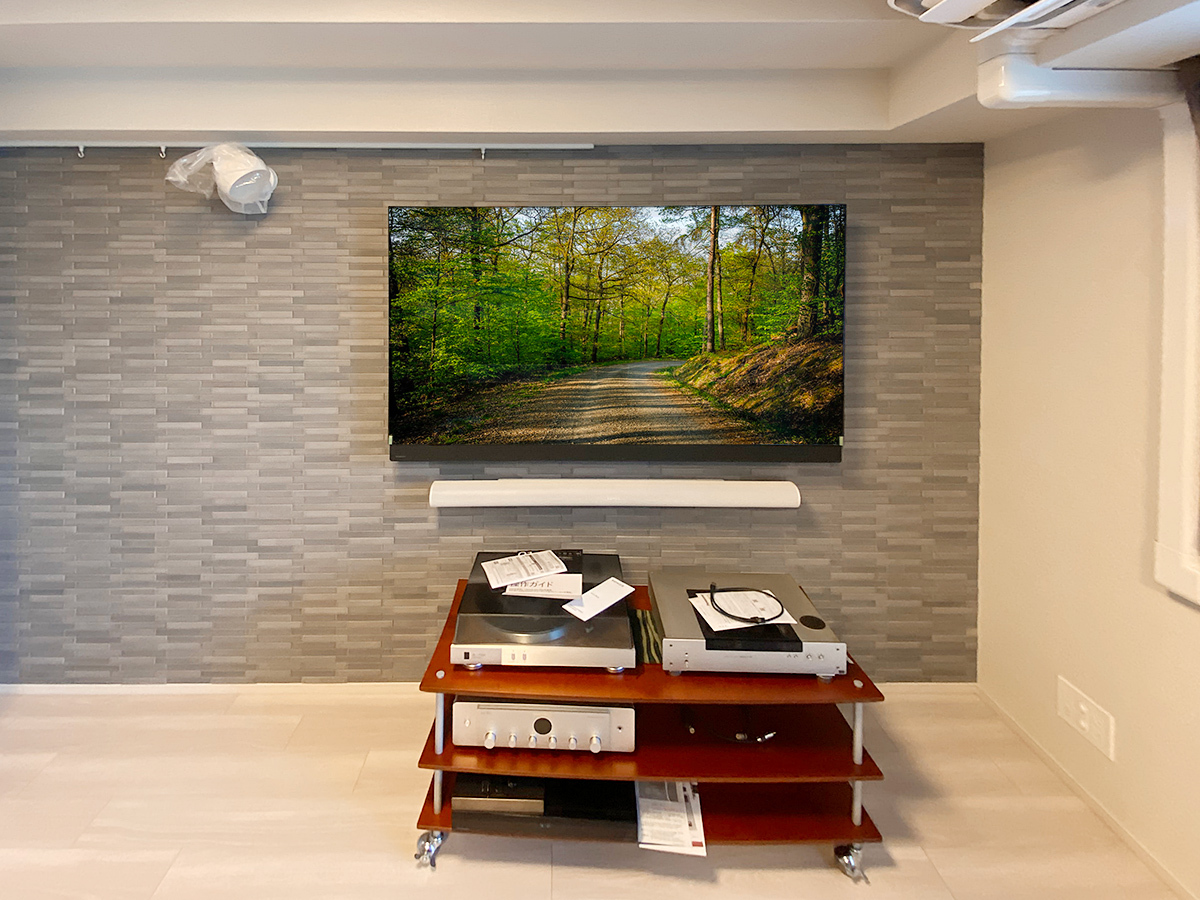 テレビ下にはサウンドバーも壁掛け。テレビとは壁内経由の配線でつながっています。左上にはウォールライトを取り付けました。