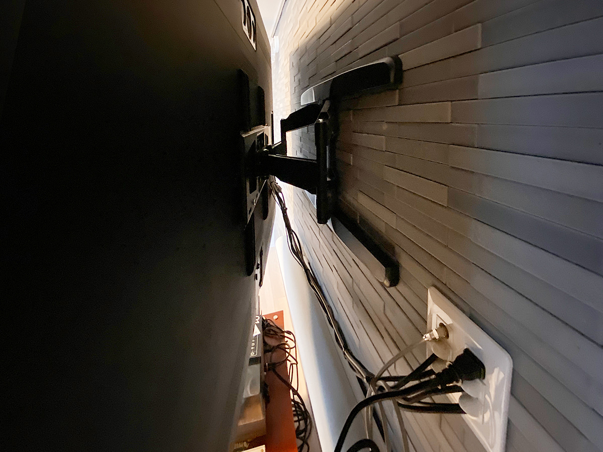 テレビ背面の様子。壁掛け金具は角度を変えられる可動式タイプ。エコカラットの上から直接取り付けることでシンプルなシルエットを実現しました。