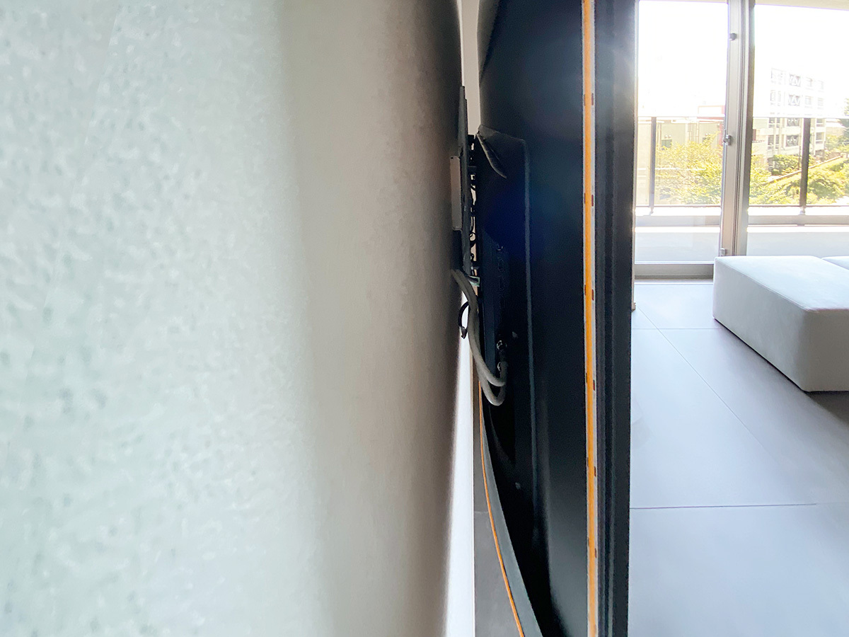壁掛け金具は薄さを重視した角度固定式タイプ。テレビ背面にはお客様ご用意のLEDライトを取り付け。