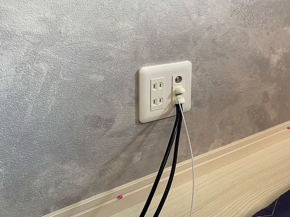 こちらはテレビボードで隠れる位置に新設したPIXYの第2コンセントパネル。対角90度壁からやってきた光ファイバーケーブルの出口となっています。