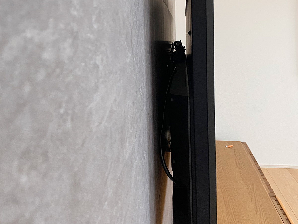 壁掛けテレビを側面から見たところ。壁掛け金具は薄さ重視の角度固定式タイプです。PIXYの上から直接取り付け・固定しています。
