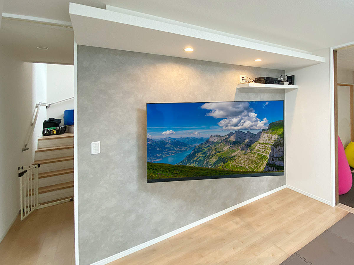 愛知県豊田市で壁紙を張り替え、壁内補強を施し、壁内に配線を巡らせてから65型テレビを可動式タイプの金具で壁掛けしました。