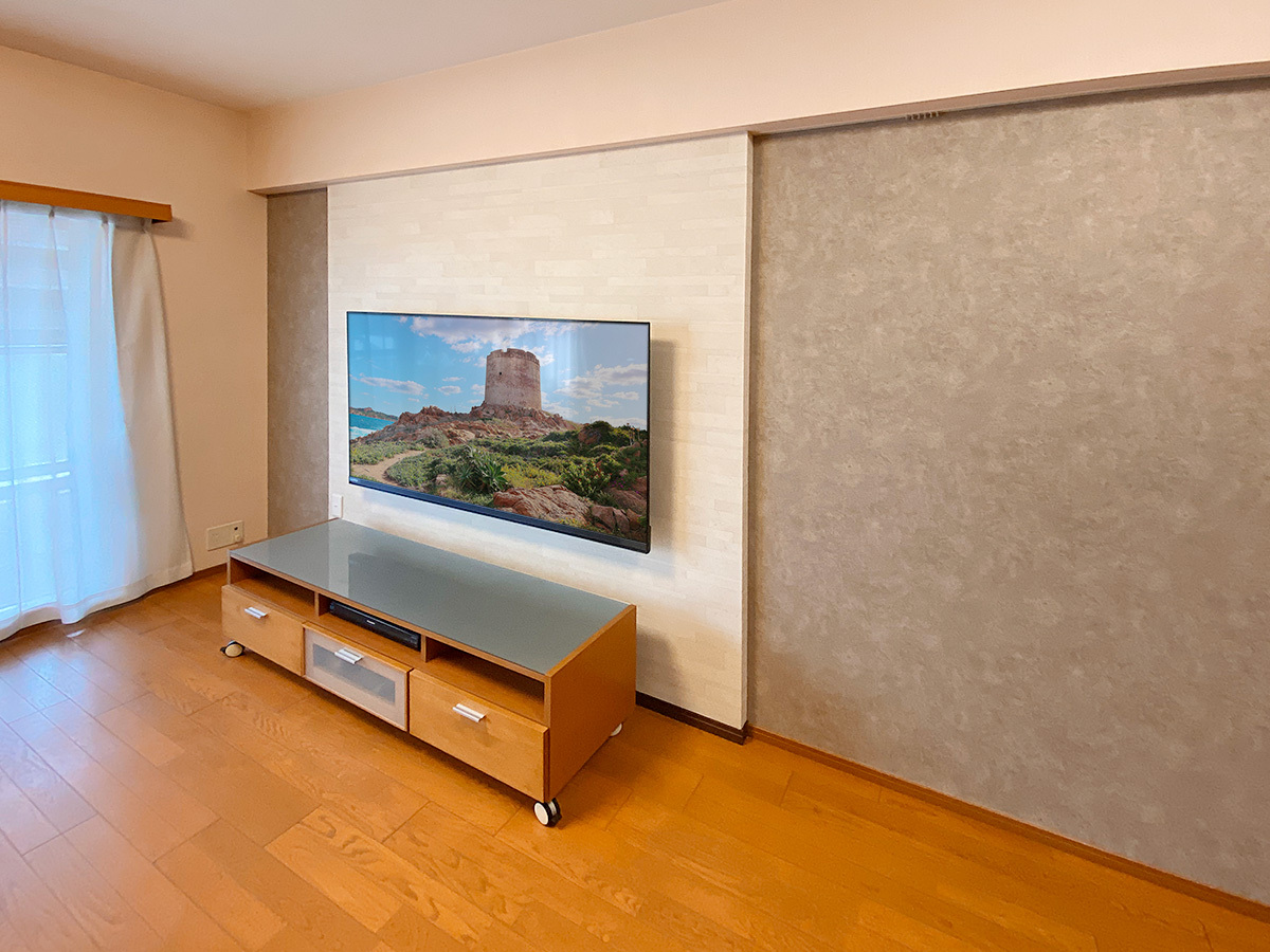 神奈川県横浜市のマンションで壁一面のクロスを張り替えたあと、フェイクウォールPIXYを設置して65インチテレビを壁掛けしました。