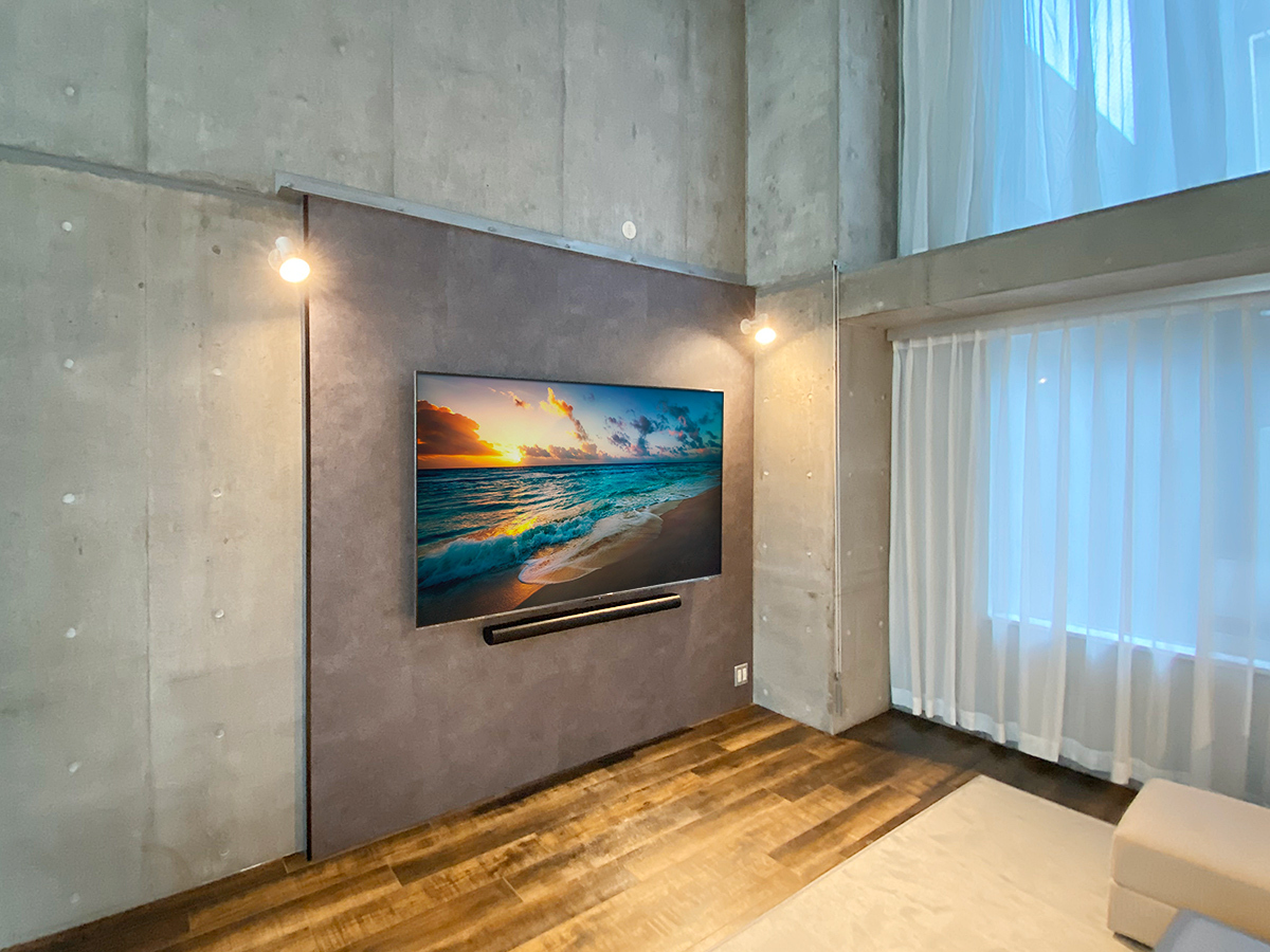PIXYを設置した後に85インチの大型テレビとサウンドバーを壁掛けしました。右下にはコンセントパネルもご用意。