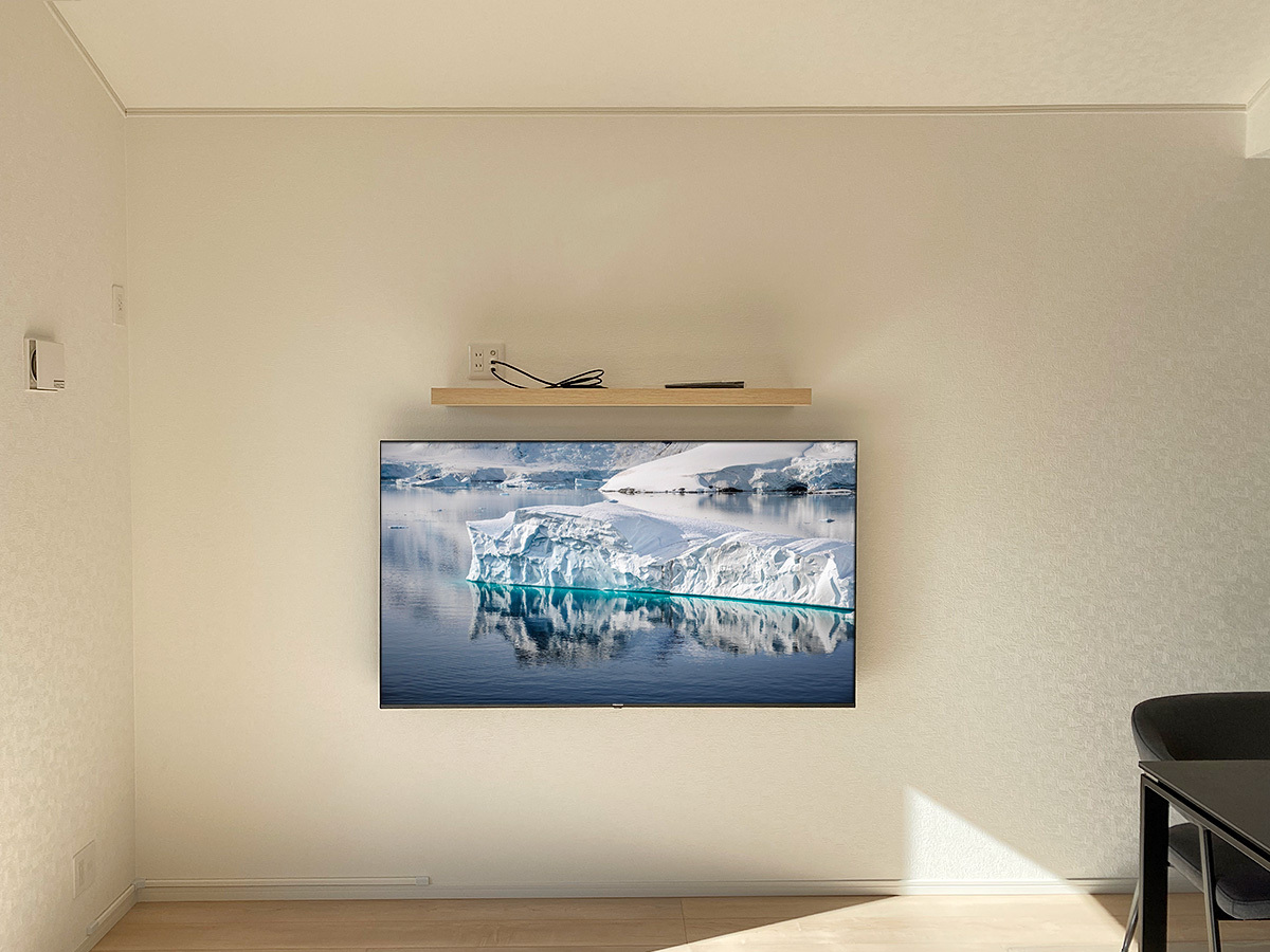 この壁自体にはコンセントやアンテナ端子が無いため、左の壁から100ボルト線などを延長し、一度壁内に入れてからテレビと棚に配線しています。