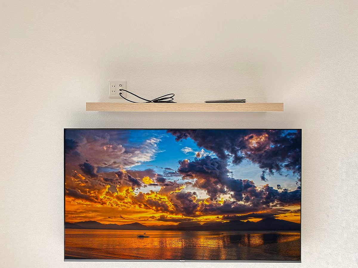 棚に用意された専用コンセント。HDMIケーブルなどは目立たないよう壁内を経由して壁掛けテレビ本体へとつながっています。