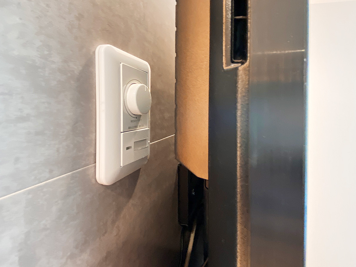 テレビ背面に作られた間接照明用のダイヤル式調光スイッチパネル。上側は明るさ調整用のダイヤル。下側はオン・オフの切り替えスイッチになります。