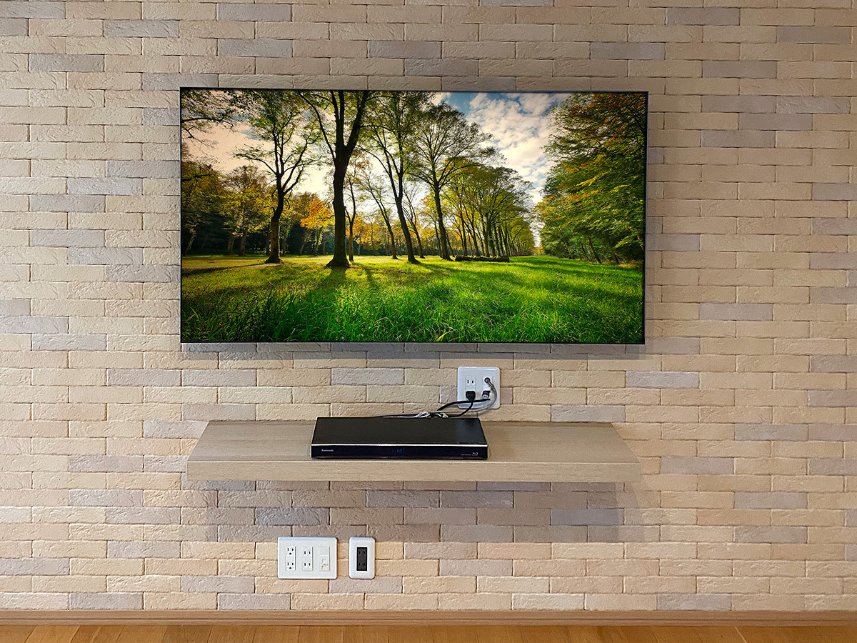 テレビ下にウォールシェルフ(棚)を設置し、レコーダ置き場として活用。レコーダー用の専用コンセントも新たにご用意しました。