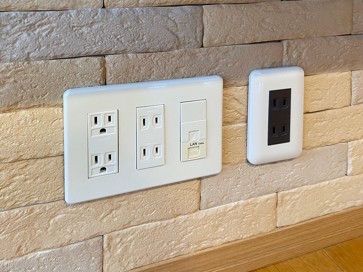 既存の床上コンセント。一旦分解して100ボルト電源やアンテナ線を分岐し、テレビ裏のコンセントへと壁内延長しています。