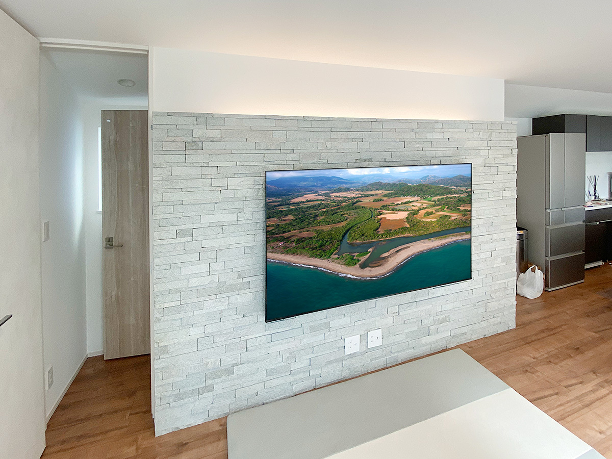 アドヴァン製のタイル壁(ナチュラルロブソンスタック)に75型テレビを壁掛けしてHDMIコンセントを追加