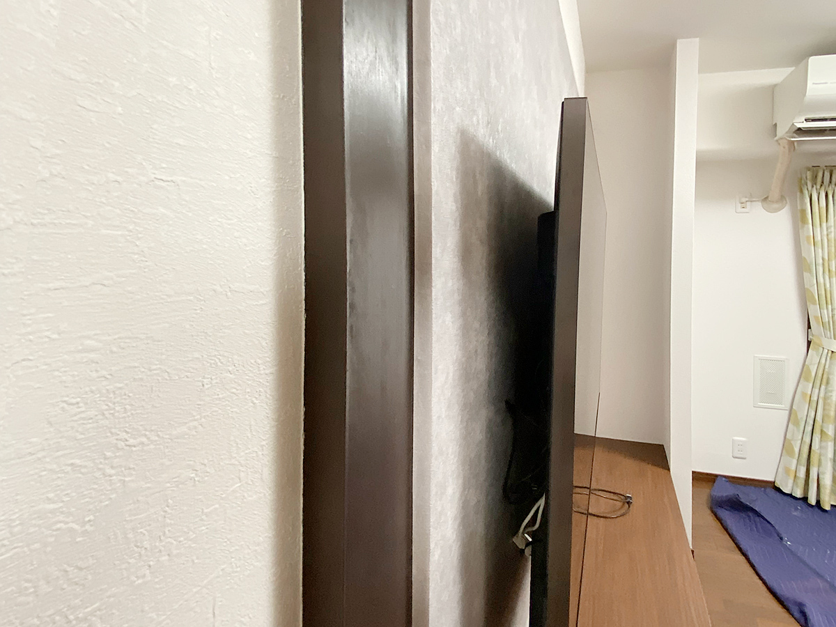 壁掛け金具は薄さを重視した角度固定式タイプ。テレビ裏の背面スペースを生かして録画用のハードディスクを取り付けています。