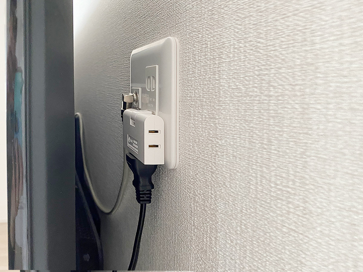 テレビで隠れる位置に新設した専用コンセントパネル。100ボルト電源の口が2つ、アンテナ端子を1つ作りました。電気工事士の資格を持つスタッフが確かな技術で、手早く目立たない場所にコンセントを作ります。