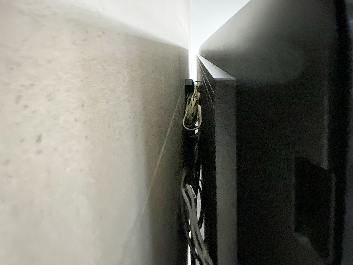 横から覗き込んだところ。エコカラットの上に直接壁掛け金具を設置し、テレビ本体を壁掛けしています。金具は薄さを重視した角度固定式タイプです。