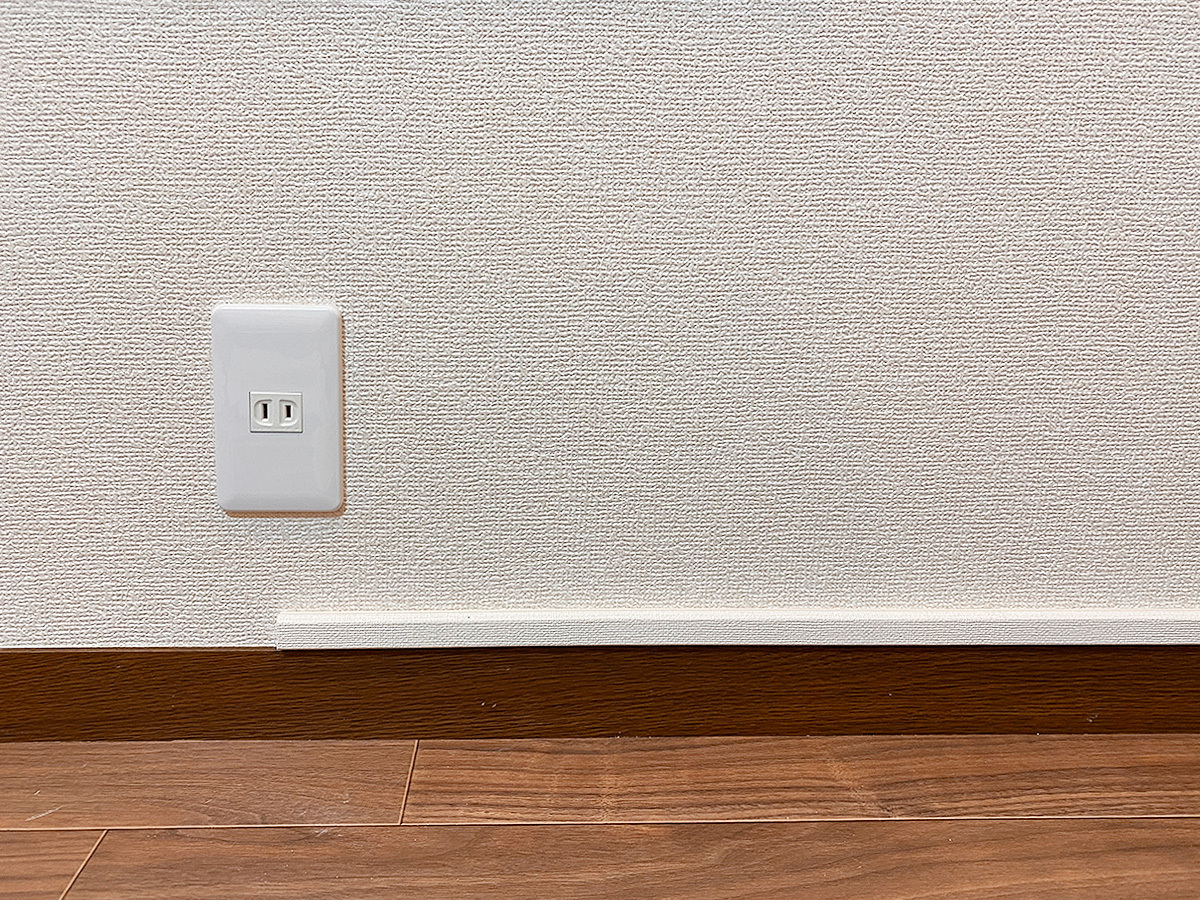 壁掛けテレビの下(床上)に新設されたコンセント。アンテナ線の中継点としての役割を持ちつつ、普通の100ボルトコンセントとしても機能します。
