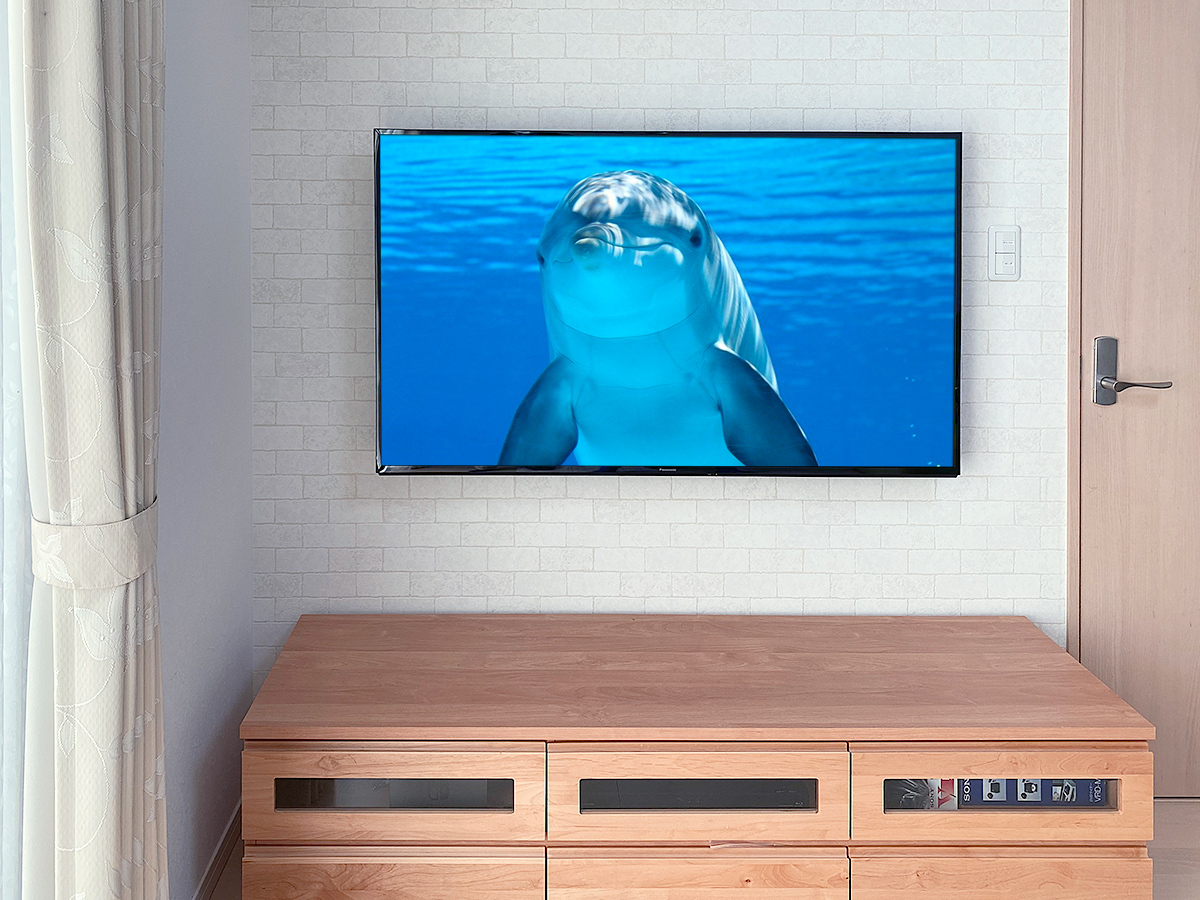 愛知県名古屋市でアクセントクロス貼りの石膏ボード壁に55型駅用テレビ（TH-55HX750）を壁掛け
