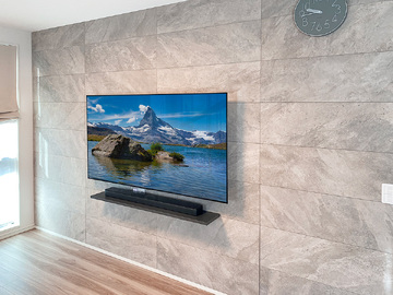 東京都三鷹市で壁一面にエコカラット(マジェスティックスレート)を貼り、65型の有機ELテレビとウォールシェルフ(棚)を壁掛け