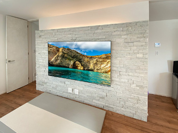 アドヴァン製のタイル壁(ナチュラルロブソンスタック)に75型テレビを壁掛けしてHDMIコンセントを追加
