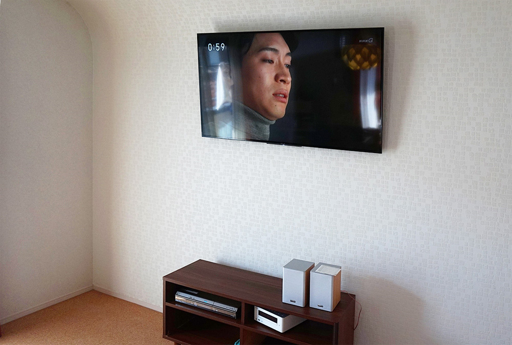 天井から壁がカーブしているお部屋で壁掛けテレビ