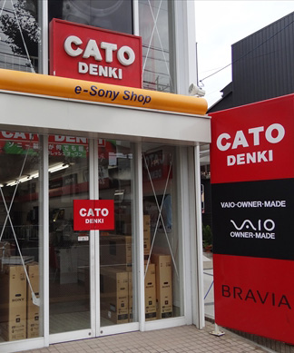 カトー電器の店舗写真。店内には出荷待ちの大型液晶テレビが多数見えます。