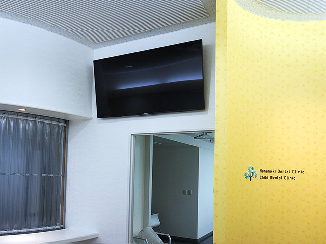 待合室に55インチの大型テレビを壁掛け。上下可動式金具で見えやすいようにしています。